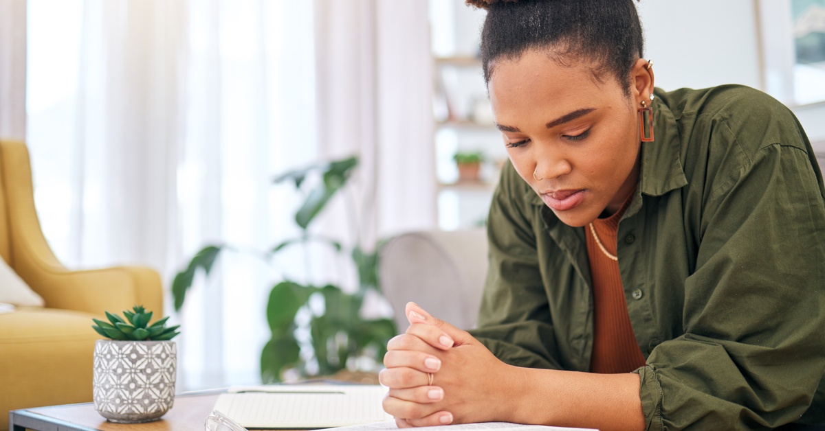 Reasons To Use a Commentary for Bible Study In a well-lit room, a woman intently reads a book that lies open on a coffee table. She clasps her hands over the book.