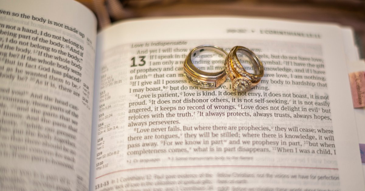 Reasons To Use a KJV Bible as a Wedding Guest Book Two gold wedding rings rest on an open Bible near 1 Corinthians 13:4, which begins "Love is patient, love is kind."
